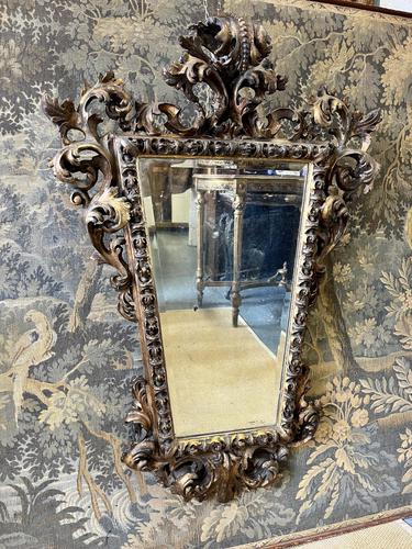 19TH CENTURY HEAVILY CARVED WALL MIRROR IN THE GOTHIC MANNER