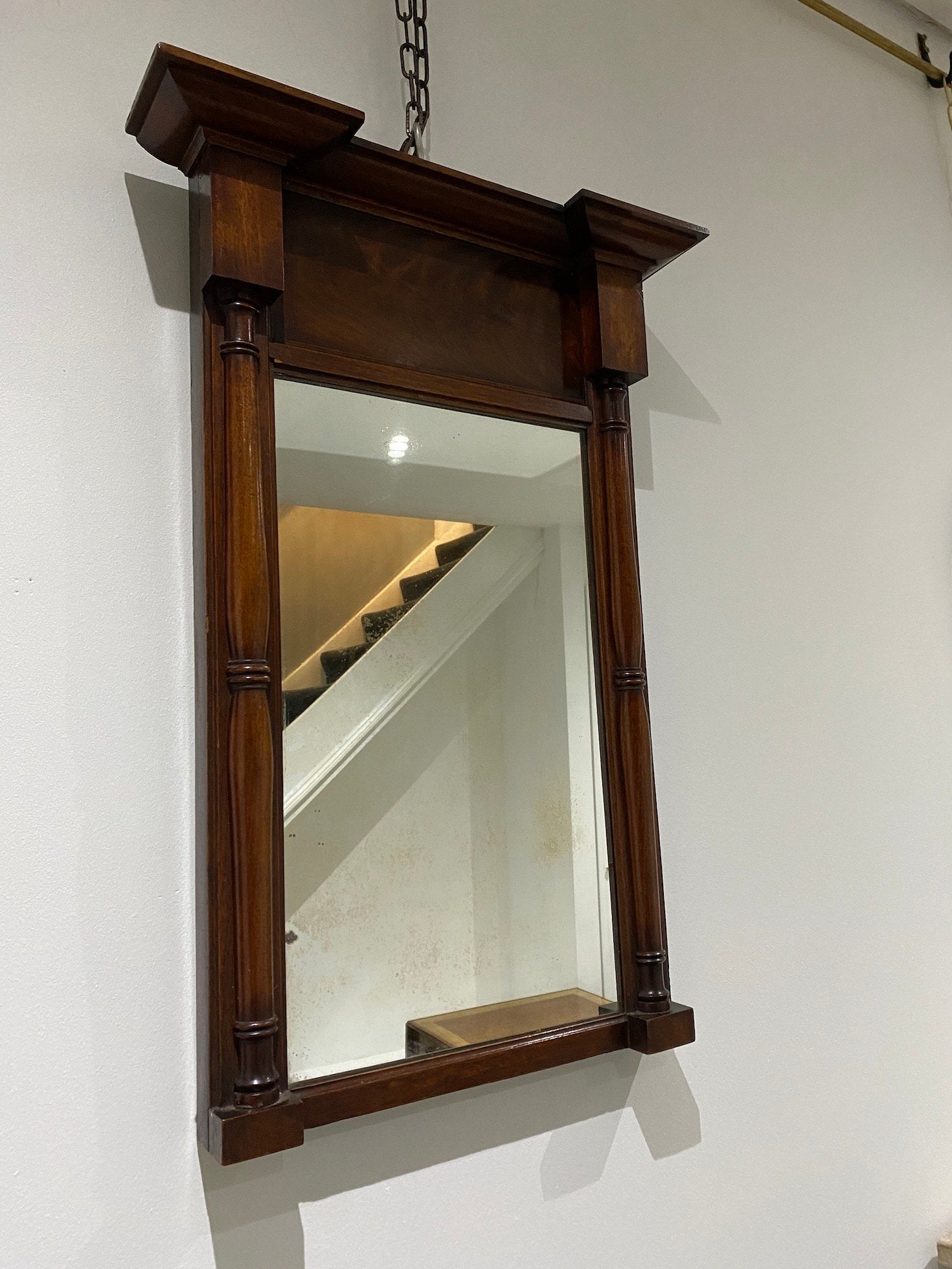 19TH CENTURY MEDIUM MAHOGANY PIER MIRROR WITH MOULDED CORNICE OVER FLAME MAHOGANY FRIEZE. OLD GLASS PLATE SET WITHIN TURNED COLUMN FRAME CIRCA 1820.