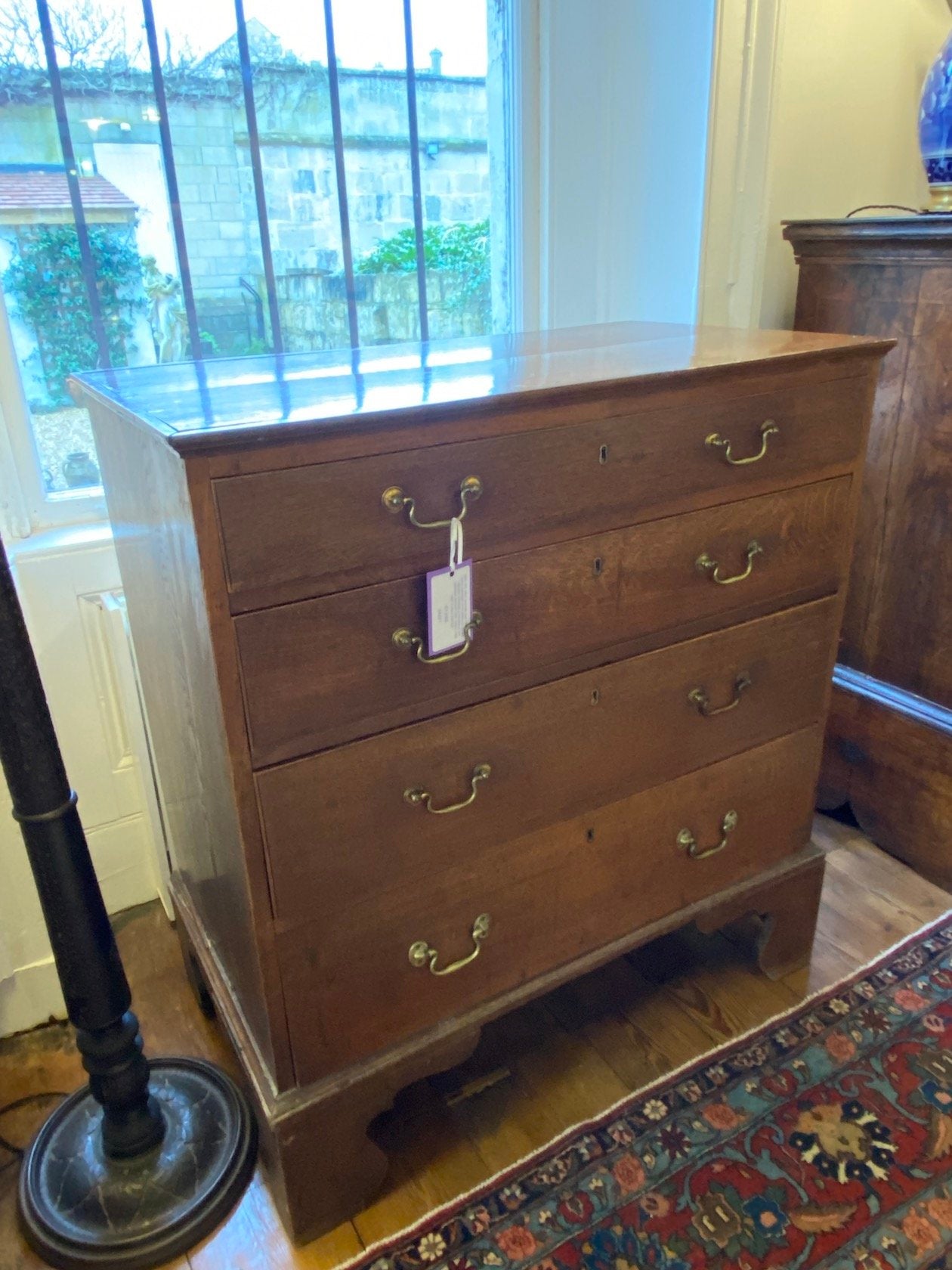 ANTIQUE LATE 18TH CENTURY OAK CHEST OF 4 LONG DRAWERS WITH ORIGINAL SWAN-NECKED HANDLES AND STANDING ON ORIGINAL BRACKET FEET. CIRCA 1780