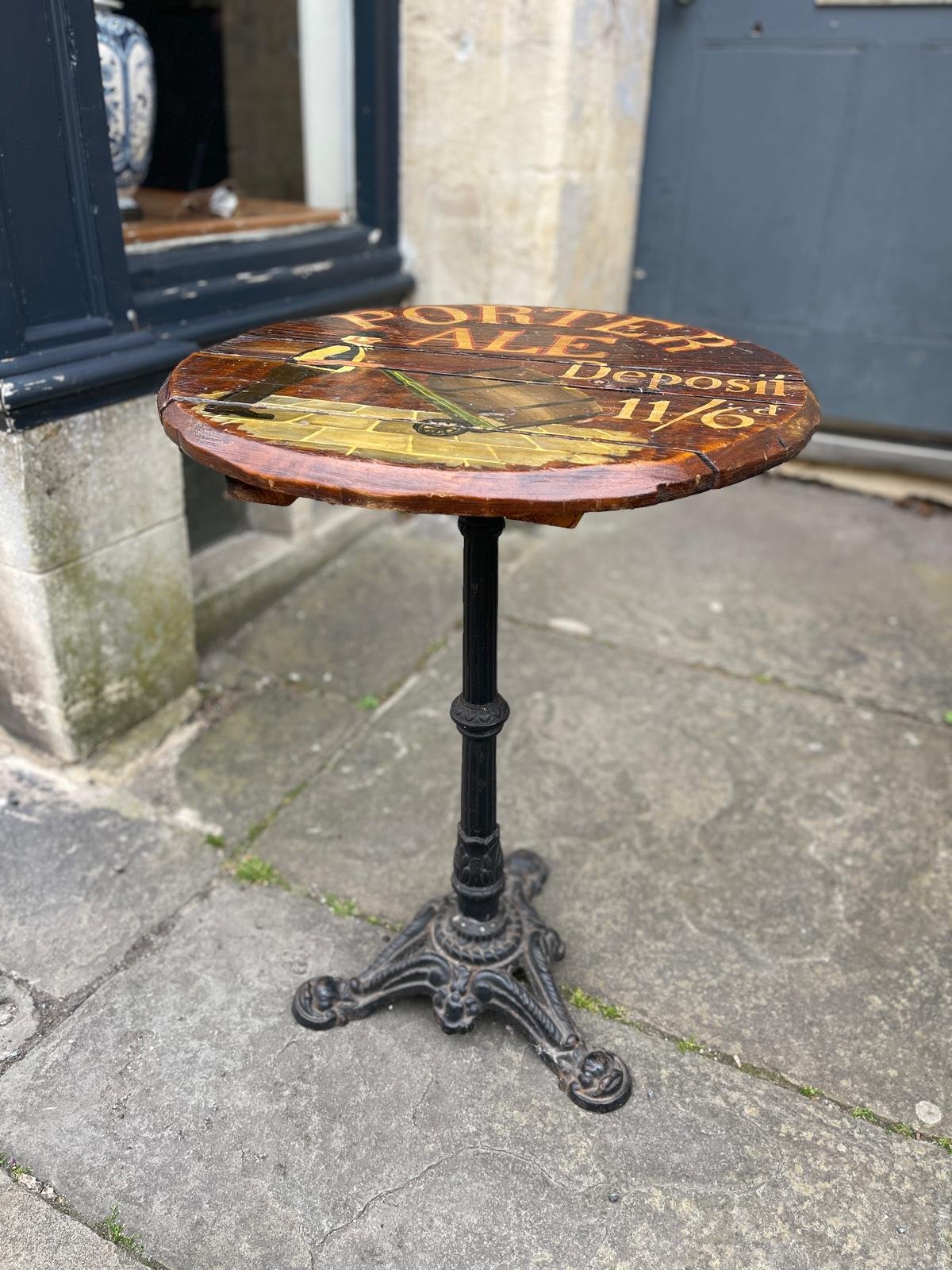 AN UNUSUALLY PAINTED BARREL PUB TABLE UPON AN IRON BASE