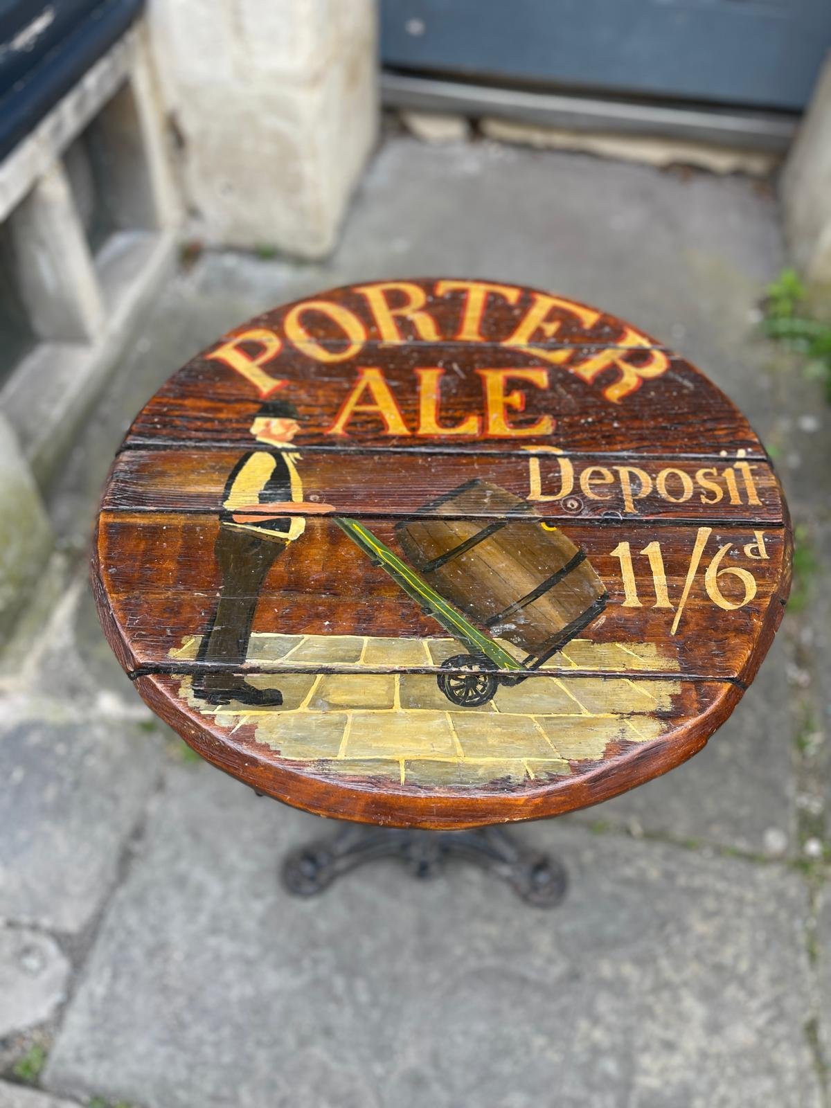 AN UNUSUALLY PAINTED BARREL PUB TABLE UPON AN IRON BASE