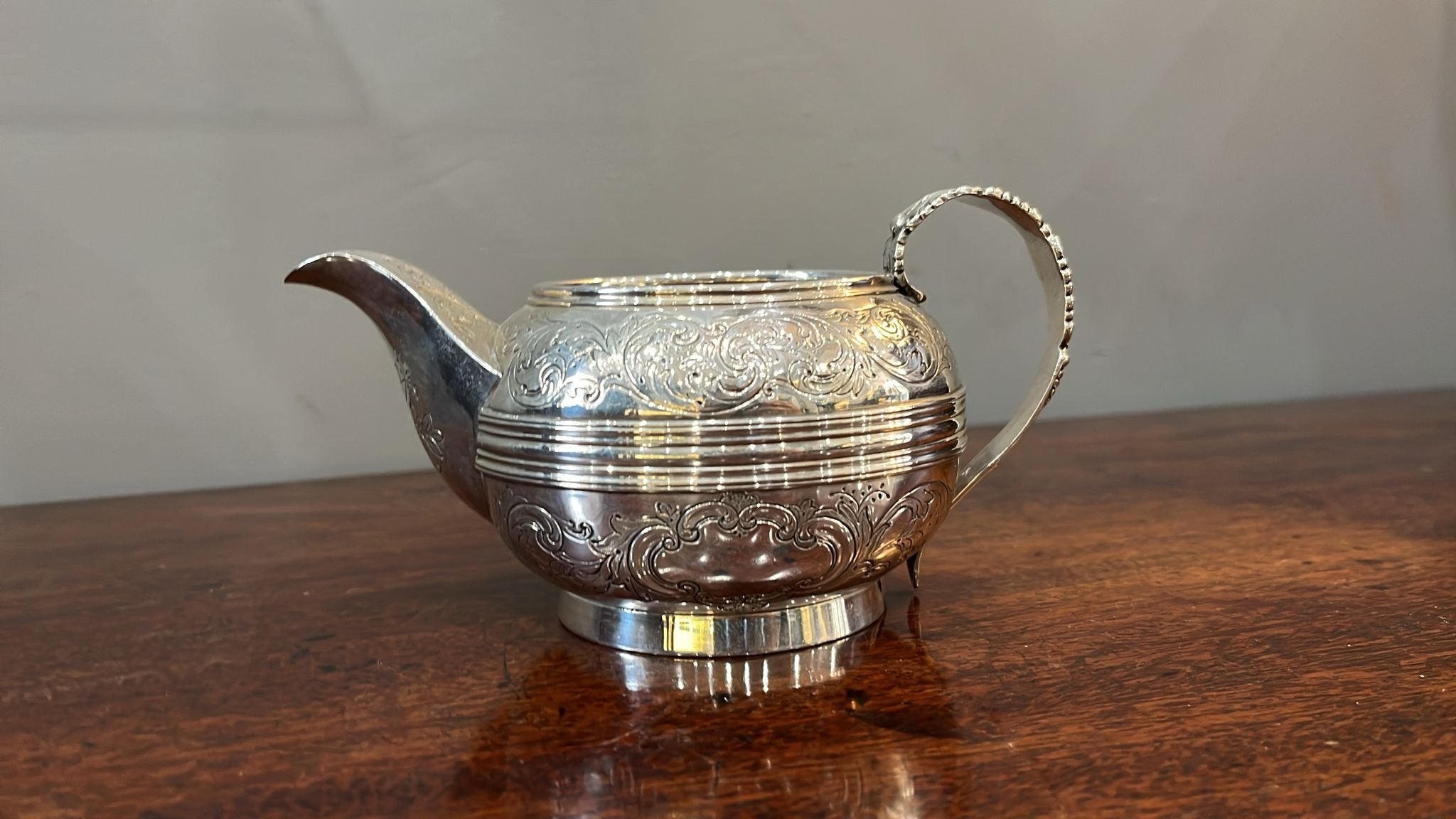 Silver cream jug with enclosed spout and gilt interior. Ribbon & leaf pattern with leaf layered handle. London 1824 (BN585)