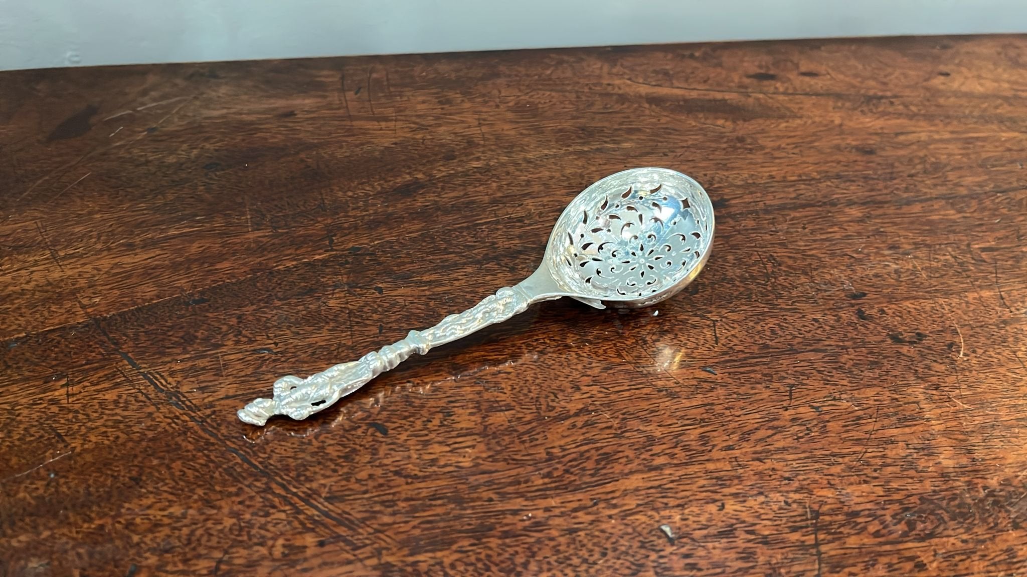 Decorative and heavy silver sugar sifting spoon with lady in dress on stem. London 1880. (BN889)